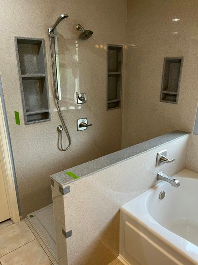 Newly renovated bathroom showing a walk-in shower, freestanding bath and recessed ceiling lights.