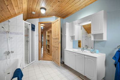 Contemporary bathroom with a glass shower enclosure, vanity unit and mirrored cabinet lighting.